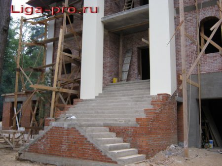 Массивная бетонная лестница на второй этаж с укороченным входом