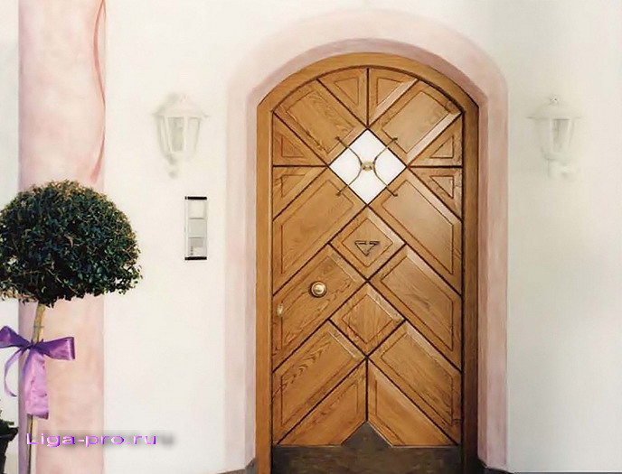 Входная деревянная дверь на фоне гладкой штукатурки